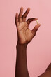 © Anna Tabakova/Stocksy - Dark skinned hand holding a pill