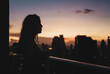© Pedro Merino/Stocksy - Woman looking at the view of skyscrapers