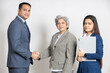 Indian senior corporate woman boss hand shake with young business man having a deal isolated on white studio background,