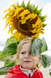 © Sergey Narevskih/Stocksy - Portrait of little kid under sunflower
