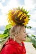 © Sergey Narevskih/Stocksy - Happy child standing under sunflower in field