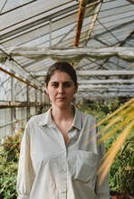 Serious Woman In A Sunny Greenhouse