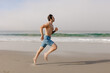 © Ameris Photography Inc./Stocksy - Man running on sandy beach.