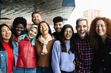 Young multi ethnic friends having fun together hanging out in the city - Friendship and diversity concept