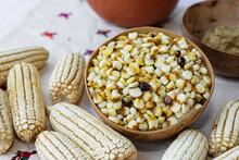 Jicara With Uncooked Yellow Corn Kernels And Corn Next To It 
