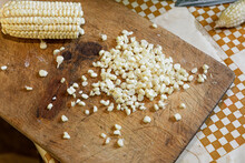 White Corn Kernels And Elote On A Wooden Chopping Board