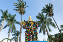 Colorful Statue With Hat And Palm Trees In The Background