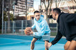 © Pedro Merino/Stocksy - Young men playing basketball in the neighborhood