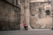 © Ibai Acevedo/Stocksy - Stylish woman waiting at old cathedral entrance