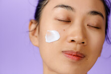 Young Asian Girl Applying Moisturizing Cream On Her Face