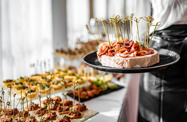 woman hands of a waiter prepare food for a buffet table in a restaurant