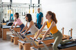 © Santi Nuñez/Stocksy - Women's team doing exercises on pilates machine
