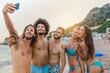 © VICTOR TORRES/Stocksy - Multi-ethnic friends taking a selfie at the beach