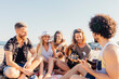 © VICTOR TORRES/Stocksy - Young friends having fun and playing guitar at the beach