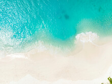 Top View Of Soft Wave Of Blue Ocean On Sandy White Beach. Background