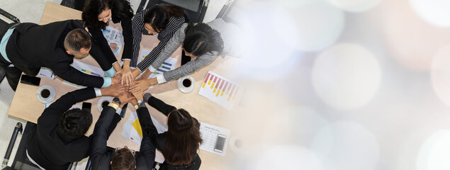 Wall Mural - Happy business people celebrate teamwork success together with joy at office table shot from top view . Young businessman and businesswoman workers express cheerful victory in broaden view .