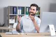 © Liubomir - Cheerful and happy man records audio messages, freelance businessman in office, uses application on smartphone