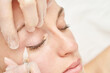 © elenavolf - Permanent makeup. Beauty spa procedure. young woman. Face tattoo. Eye micropigmentation. Professional face microblading. Female cosmetology device. Copyspace. Mouth treatment. Dermatology