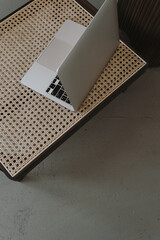 Wall Mural - Flatlay of laptop computer on luxury rattan lounge chair. Work at home, freelance, online shopping, online store, blog, social media branding concept