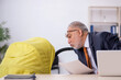 Old male employee looking after new born at workplace