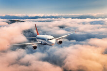 Airplane Is Flying Above The Clouds At Sunset In Summer. Landscape With Passenger Airplane, Beautiful Clouds,  Blue Sky. Aircraft Is Taking Off. Business Travel. Commercial Plane. Aerial View