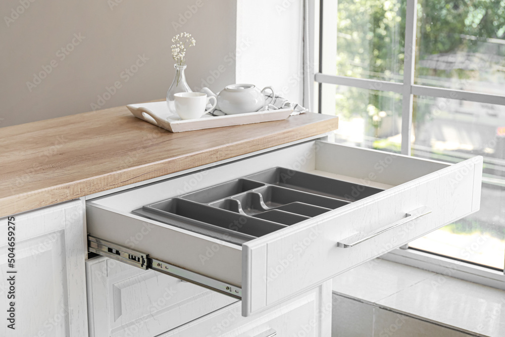 Open empty drawer for cutlery in modern kitchen