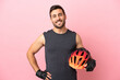 © luismolinero - Young cyclist man isolated on pink background posing with arms at hip and smiling
