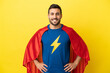 © luismolinero - Young handsome caucasian man isolated on yellow background in superhero costume posing with arms at hip and smiling