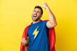 © luismolinero - Young handsome caucasian man isolated on yellow background in superhero costume and celebrating a victory