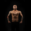 © A Stock Studio - Muscular male bodybuilder with a naked toros on a black background.