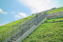 A Traveler Stands On A White Stairway On A Verdant Hillside