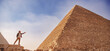 Man tourist with hat stand background of pyramids Cairo Egypt, sunlight. Concept travel banner