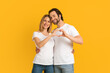 © Prostock-studio - Happy attractive millennial european wife and husband with stubble in white t-shirts make heart with hands