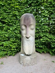 stone sculpture on a background of green plants