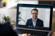 © fizkes - Laptop display with interface of video call to happy successful millennial businessman, business leader, coach, mentor, online teacher. Computer monitor with head shot portrait on work table