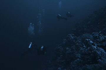 divers underwater at depth in the blue sea background