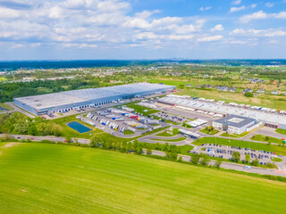 Wall Mural - Aerial view of goods warehouse. Logistics center in industrial city zone from above. Aerial view of trucks loading at logistic center