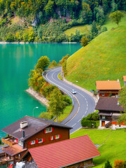Wall Mural - lungern, canton of obwalden, switzerland. a view of rural homes in a green meadow. a lake in a mount