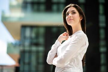 Wall Mural - Confident young female manager outdoor in a modern urban setting