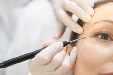 Woman receiving facial skincare treatment in cosmetology clinic