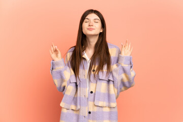 Wall Mural - Young Ukrainian girl isolated on pink background in zen pose