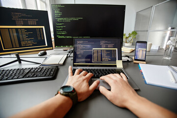 POV of QA engineer typing on keyboard while using computer at workplace in office, copy space