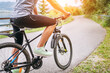 © Soloviova Liudmyla - Close-up photo of a man dressed in cycling clothes starting riding a modern bicycle on the asphalt out-of-town bicycle path. Active sporty people concept image.