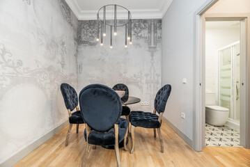 dining room with round glass table, capitone upholstered chairs with blue velvet and oak wood floors