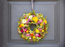 Flower Wreath Hanging On A House Front Door. Fresh Wild Flower And Herb. Spring Sunny Day