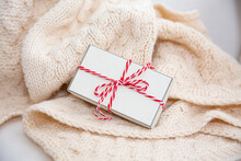 Gift Box Wrapped With Red And White String On Woolen Blanket