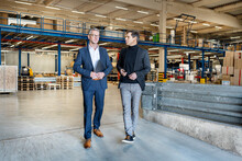 Business People Discussing And Walking In Warehouse