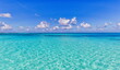 canvas print picture Bright beautiful seascape, sandy beach, clouds reflected in the water, natural minimalistic background and texture, panoramic view banner. Sea ocean ecology nature concept. Blue sky clouds, idyllic
