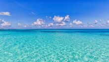 Bright Beautiful Seascape, Sandy Beach, Clouds Reflected In The Water, Natural Minimalistic Background And Texture, Panoramic View Banner. Sea Ocean Ecology Nature Concept. Blue Sky Clouds, Idyllic