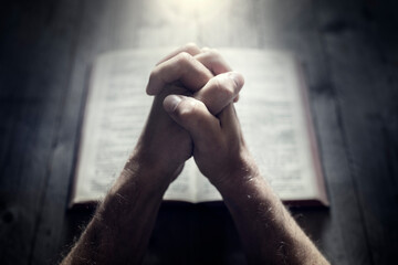 Canvas Print - Hands folded in prayer on a Holy Bible in church, faith, spirtuality and religion